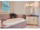Spacious bathroom with tiled whirlpool tub, light cabinetry, and plant accent at 1056 James Madison Dr, Matthews, NC 28104