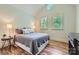 Bedroom with a comfortable bed, wood floor, and light filled windows with plantation shutters at 1056 James Madison Dr, Matthews, NC 28104