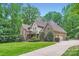 Charming two-story home with a well-manicured lawn, lush landscaping, and inviting curb appeal at 1056 James Madison Dr, Matthews, NC 28104