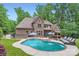 Luxury brick home featuring a beautiful pool and hot tub, perfect for outdoor relaxation and entertaining at 1056 James Madison Dr, Matthews, NC 28104
