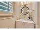 Cozy powder room with a round mirror, white vanity, and lovely decorations at 1056 James Madison Dr, Matthews, NC 28104