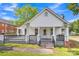 Charming home featuring a cozy front porch and black railing, complemented by green grass and blue skies at 111 E Church St, Stanley, NC 28164