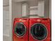 Bright laundry room features red Samsung washer/dryer, white cabinets and shelving, and walk-in shower at 111 E Church St, Stanley, NC 28164