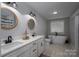 Bright bathroom featuring double vanities, round mirrors, hexagon tile floor and soaking tub under a window at 1138 Zeb Haynes Rd, Maiden, NC 28650