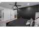 Main bedroom with black accent wall, ceiling fan, and wood-look flooring that leads to an ensuite bathroom at 1138 Zeb Haynes Rd, Maiden, NC 28650