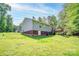 View of the backyard featuring a gray house with a brick foundation and a small wooden deck at 1170 Scenic Dr, Shelby, NC 28150