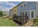 A backyard view with a quaint wooden deck, green lawn, and colorful home exteriors provides a serene outdoor living space at 12531 Bryton Ridge Pkwy, Huntersville, NC 28078