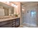 Dual vanity bathroom featuring granite counters, dark wood cabinets and walk-in shower at 12531 Bryton Ridge Pkwy, Huntersville, NC 28078