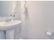 Bright powder room with a pedestal sink, white walls, and modern fixtures at 12531 Bryton Ridge Pkwy, Huntersville, NC 28078