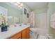 Charming bathroom with wooden cabinets, vanity, and tub with shower, styled with floral decor at 130 Greenwich Dr, Statesville, NC 28677