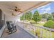 Inviting front porch with rocking chairs and ceiling fans overlooks landscaped yard with water feature and lush greenery at 130 Greenwich Dr, Statesville, NC 28677