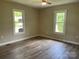 A bright bedroom features laminate flooring and neutral walls with bright windows at 1327 Wiscassett St, Albemarle, NC 28001