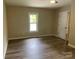A bright bedroom features laminate flooring and neutral walls with a bright window at 1327 Wiscassett St, Albemarle, NC 28001