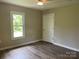 A bright bedroom features laminate flooring and neutral walls with a closet and window at 1327 Wiscassett St, Albemarle, NC 28001