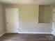 A bright bedroom features laminate flooring and neutral walls with a closet and window at 1327 Wiscassett St, Albemarle, NC 28001