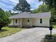 Charming single-story home featuring a covered front porch, neutral siding, and a gravel driveway at 1327 Wiscassett St, Albemarle, NC 28001