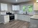Updated kitchen with white cabinets, granite countertops, and stainless steel appliances at 1327 Wiscassett St, Albemarle, NC 28001