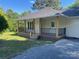 Inviting front porch with black railing, wooden posts, and a well-maintained yard at 1327 Wiscassett St, Albemarle, NC 28001