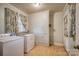 Laundry room with washer, dryer, storage, and window with patterned curtains at 1503 Brentwood Dr, Newton, NC 28658