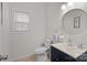 Bright half bath featuring a navy vanity cabinet, circular mirror, and contemporary fixtures at 1572 Edenton Nw St, Concord, NC 28027