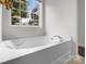 This white bathtub is surrounded by a large window with natural light at 1572 Edenton Nw St, Concord, NC 28027
