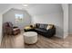 Comfortable bonus room featuring a black sofa, a leather recliner, and a patterned coffee table at 1572 Edenton Nw St, Concord, NC 28027