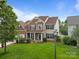 Beautiful home with a lush green lawn, a mix of brick and siding, and classic blue shutters at 1572 Edenton Nw St, Concord, NC 28027