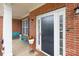 Inviting front porch with a cozy seating area, brick accents, and a stylish front door at 1572 Edenton Nw St, Concord, NC 28027