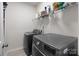 Functional laundry room featuring modern washer and dryer units with overhead shelving at 1572 Edenton Nw St, Concord, NC 28027