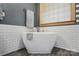 Relaxing bathroom featuring a freestanding soaking tub with elegant fixtures and white subway tile walls at 1705 Townsend Ln, Rock Hill, SC 29730