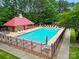 Community pool and pool house surrounded by lounge chairs, umbrellas, and lush greenery at 1705 Townsend Ln, Rock Hill, SC 29730