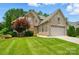 Beautiful two-story brick and stone home featuring a manicured lawn, mature trees, and an attached garage at 1705 Townsend Ln, Rock Hill, SC 29730
