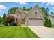 Charming two-story brick and stone home with a well-manicured lawn and attached two-car garage at 1705 Townsend Ln, Rock Hill, SC 29730
