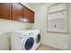 Efficient laundry room with front load washer and dryer, brown cabinets, and a window for natural light at 1705 Townsend Ln, Rock Hill, SC 29730