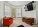 Cozy living room with a comfortable orange armchair, a dark wood entertainment center, and a bay window for natural light at 1705 Townsend Ln, Rock Hill, SC 29730