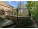 View of backyard with stone retaining wall, metal railing, and mature trees offering privacy at 171 Secretariat Dr, Mooresville, NC 28117