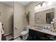 This bathroom features a granite countertop, decorative mirror, and a glass-enclosed shower for a touch of elegance at 171 Secretariat Dr, Mooresville, NC 28117