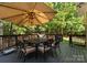 Enjoy outdoor dining on this deck featuring a table, chairs, an umbrella, and green views at 171 Secretariat Dr, Mooresville, NC 28117