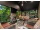 An inviting sunroom with wicker furniture surrounds a stone fire pit coffee table, perfect for relaxing with nature views at 171 Secretariat Dr, Mooresville, NC 28117