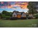 Stunning exterior view of a home at sunset, showcasing the landscaped backyard at 18718 Peninsula Cove Ln, Cornelius, NC 28031