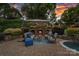 Outdoor fireplace and seating area with an in-ground swimming pool and lush landscaping at 18718 Peninsula Cove Ln, Cornelius, NC 28031