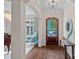 Bright foyer with hardwood floors, decorative lighting, an arched doorway and a view of an adjacent seating area at 18718 Peninsula Cove Ln, Cornelius, NC 28031