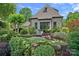 Exterior shot showing a serene stone patio area with seating and lush landscaping surrounding the home at 18718 Peninsula Cove Ln, Cornelius, NC 28031