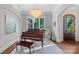 Elegant living room featuring a grand piano, chandelier, and large windows with natural light and archways at 18718 Peninsula Cove Ln, Cornelius, NC 28031
