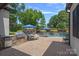 An inviting pool area boasts a built-in grill, lounge chairs, lush landscaping, and a cozy fireplace for ultimate relaxation at 18718 Peninsula Cove Ln, Cornelius, NC 28031