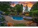Inviting outdoor pool area with a spa, lush landscaping, and a cozy seating area for relaxation and entertainment at 18718 Peninsula Cove Ln, Cornelius, NC 28031