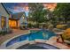Beautiful in-ground pool and outdoor kitchen space, plus lush landscaping and mature trees at 18718 Peninsula Cove Ln, Cornelius, NC 28031