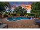 Beautiful in-ground pool featuring a waterfall, jacuzzi, and stone retaining wall with manicured bushes at 18718 Peninsula Cove Ln, Cornelius, NC 28031