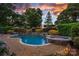 In-ground pool and jacuzzi with stone accents and mature landscaping in a private backyard setting at 18718 Peninsula Cove Ln, Cornelius, NC 28031