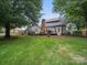 Expansive backyard featuring a deck, mature trees, and a well-maintained lawn at 2223 Jon Chris Dr, Harrisburg, NC 28075